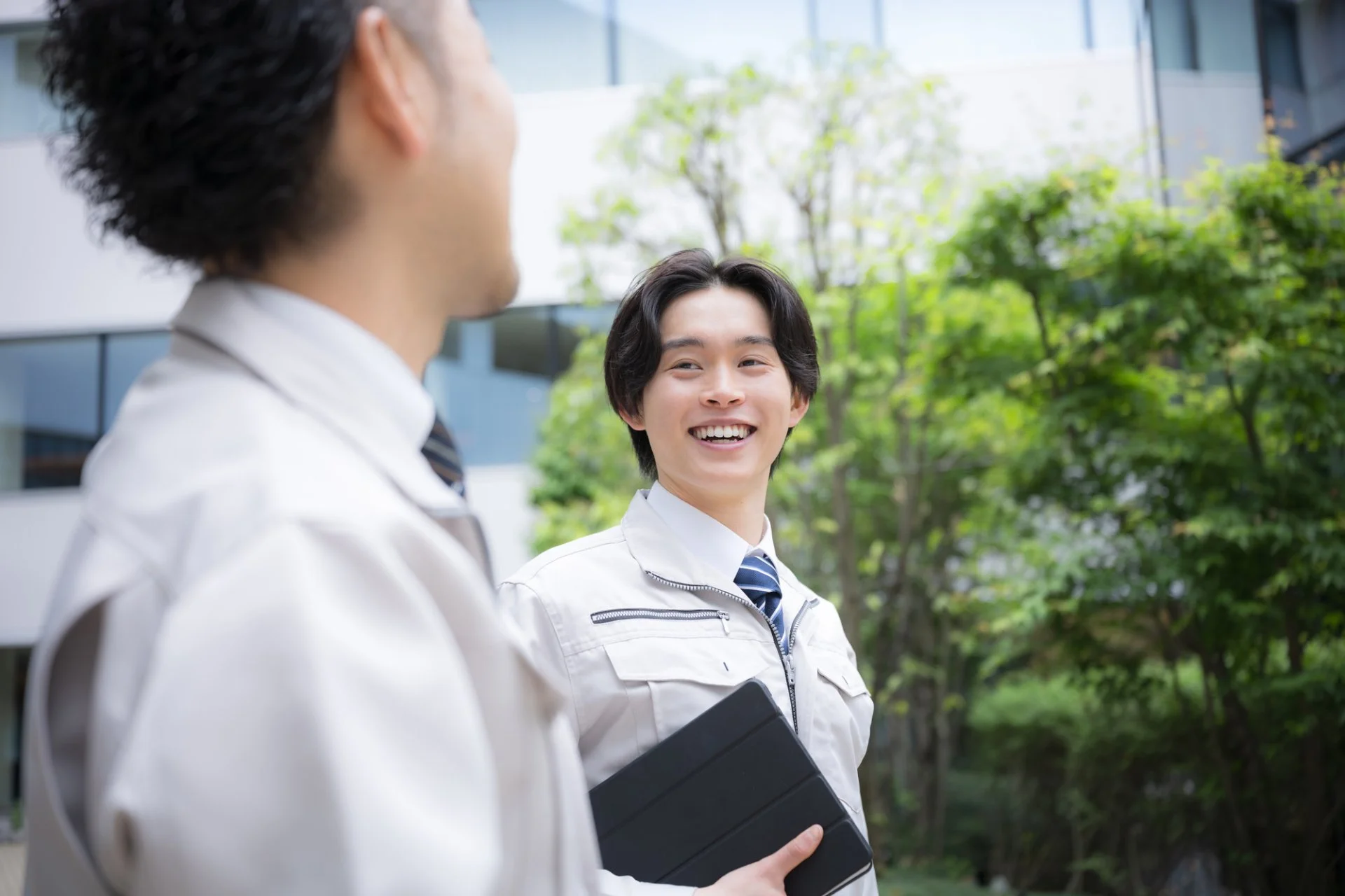室内機を点検する作業者と、そばで説明を聞く女性